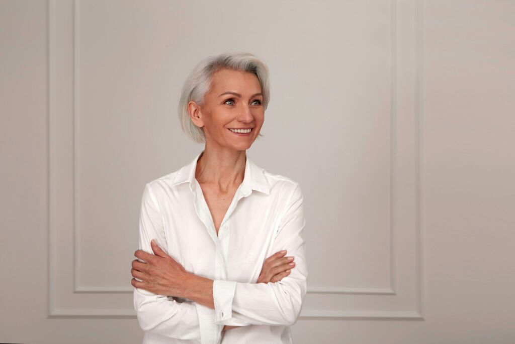 Close up portrait of beautiful older woman standing by wall